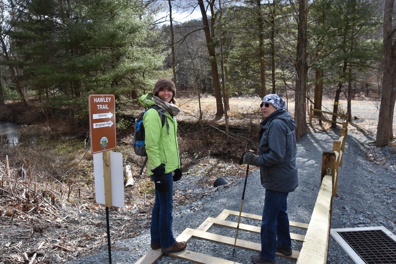 Delaware Highlands Conservancy’s Amanda Subjin and Hawley, PA business owner Grant Genzlinger discuss the history of the recently completed Hawley Trail in preparation for a guided walk on Saturday, April 18. Visit www.bit.ly/hawleyearthweek to learn more.